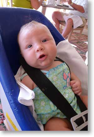  Hanging out in a plastic chair while her elders eat breakfast.